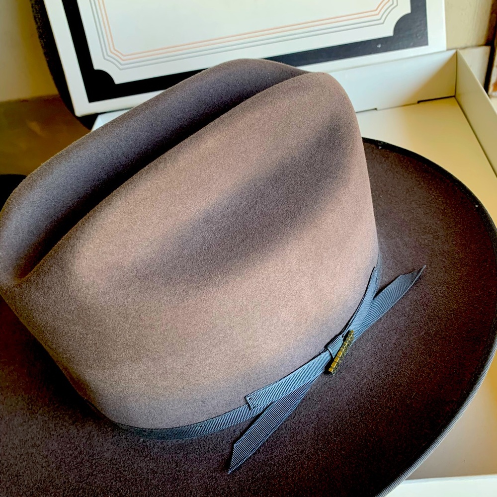 Brown suede Stetson hat with blue trim.